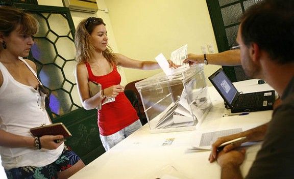 Una jove diposita el seu vot a l'urna del Casino de Sant Feliu de Llobregat.