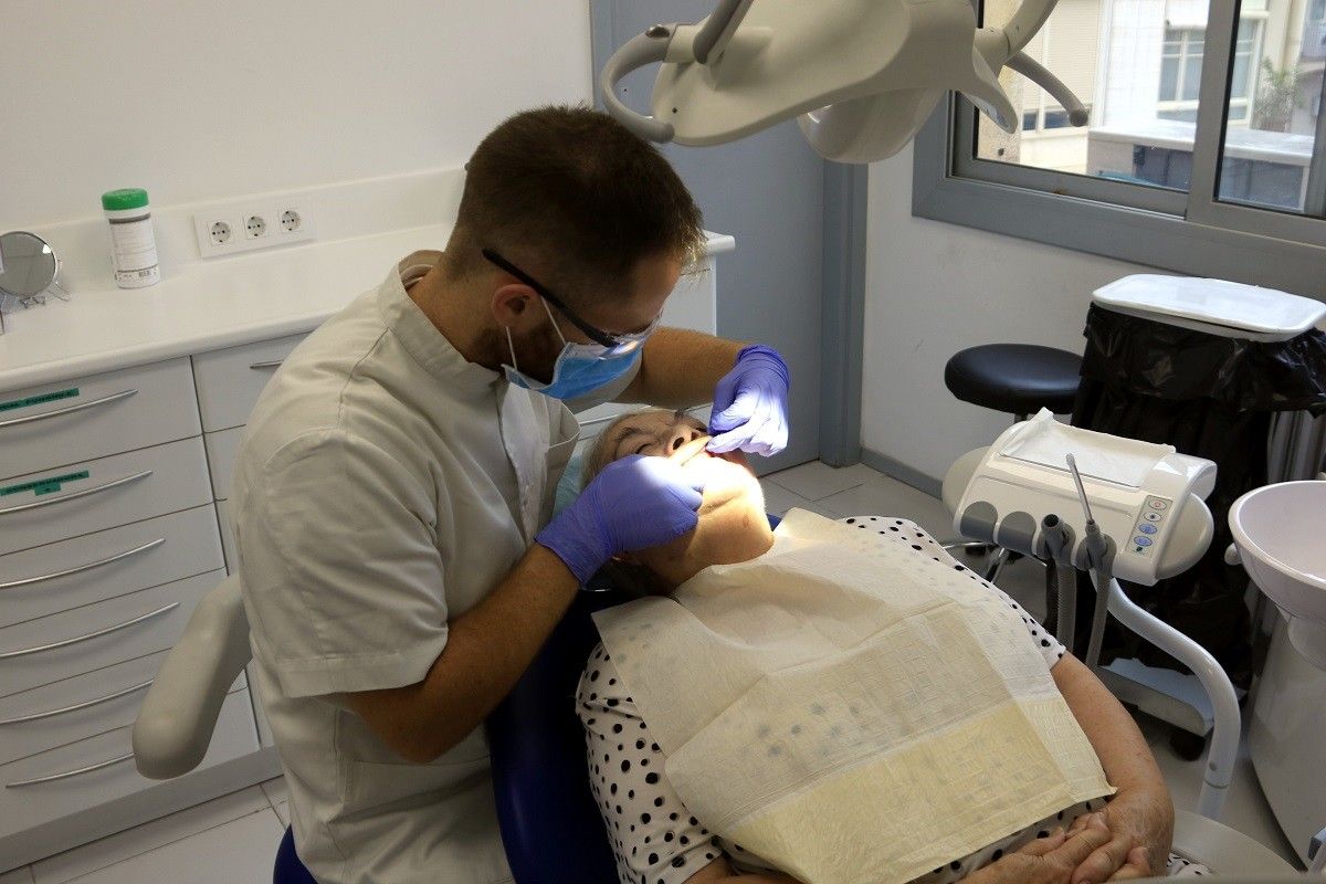 Un odontòleg atén un usuari del servei