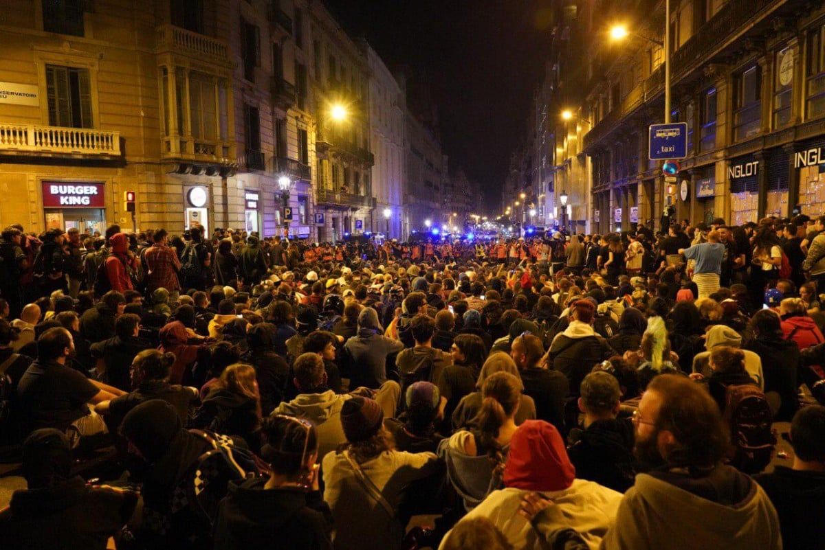 Milers de persones assegudes a la plaça Urquinaona