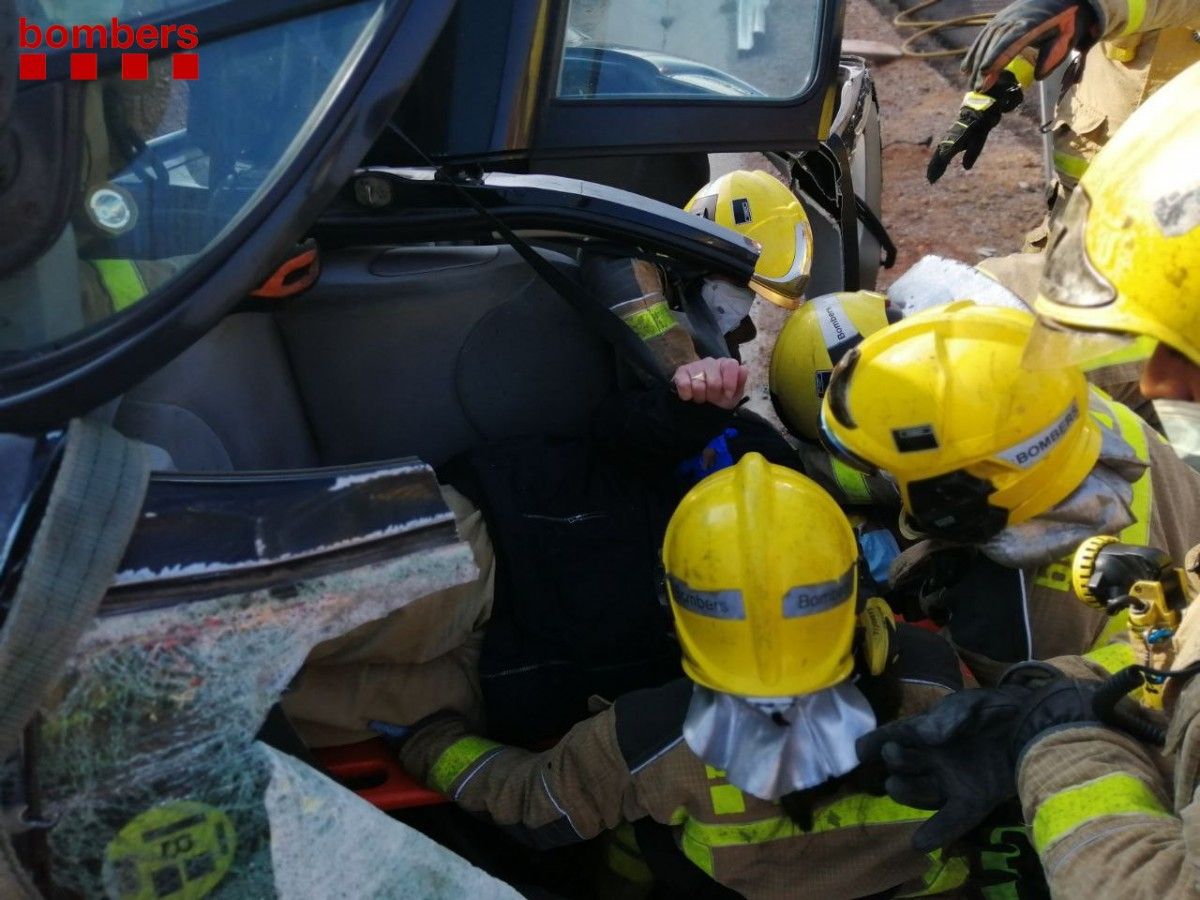 Imatge del rescat de les tres persones ocupants del vehicle bolcat a l'AP-7