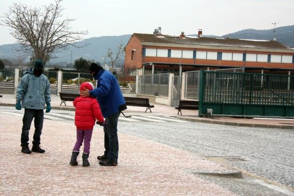 Una de les alumnes de l'escola Pere Rosselló de Calonge davant el col·legi on avui no fan classe.