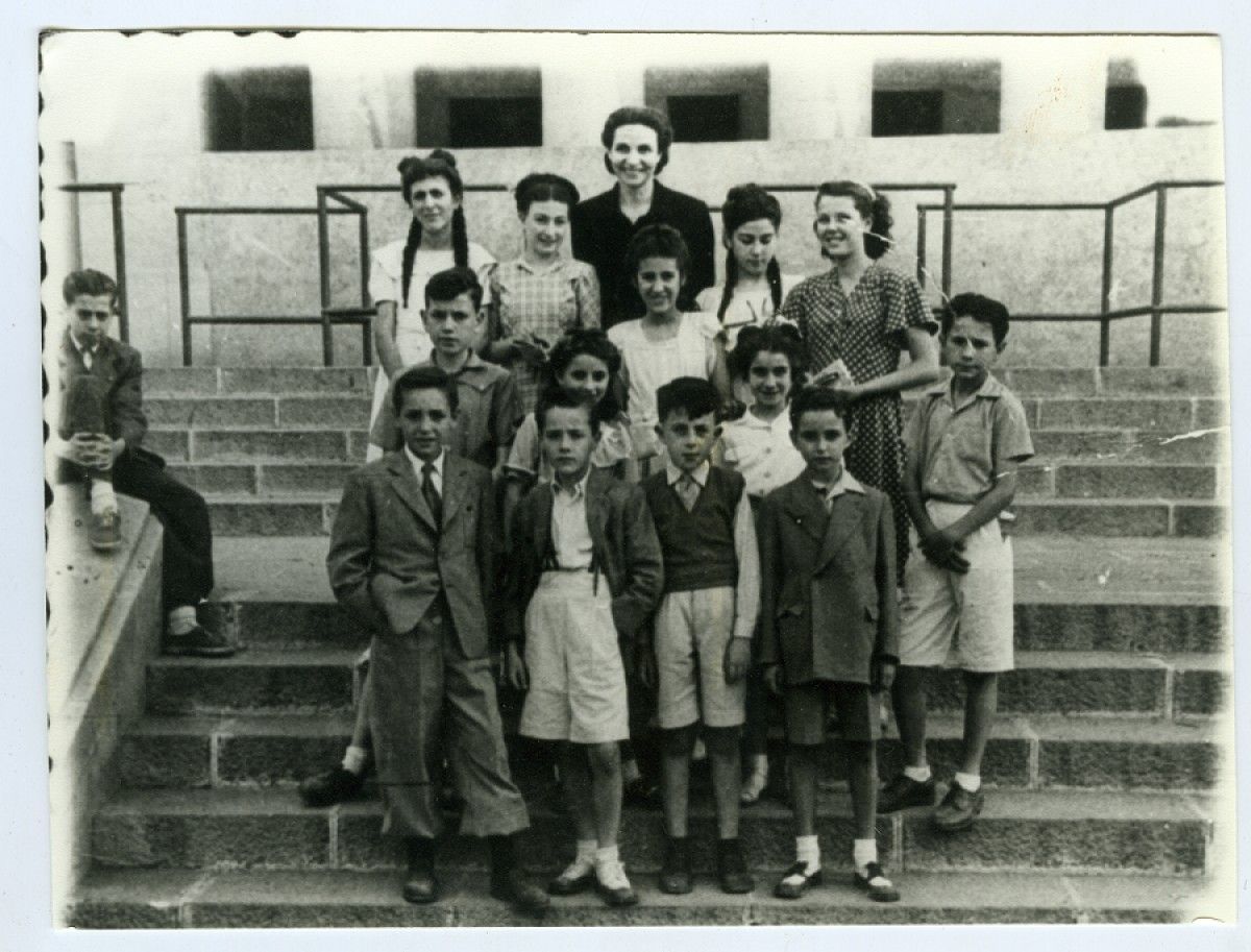 Fotografia de l'Adelita Barberà amb els seus alumnes a la Plaça d'Espanya el juny de 1948.