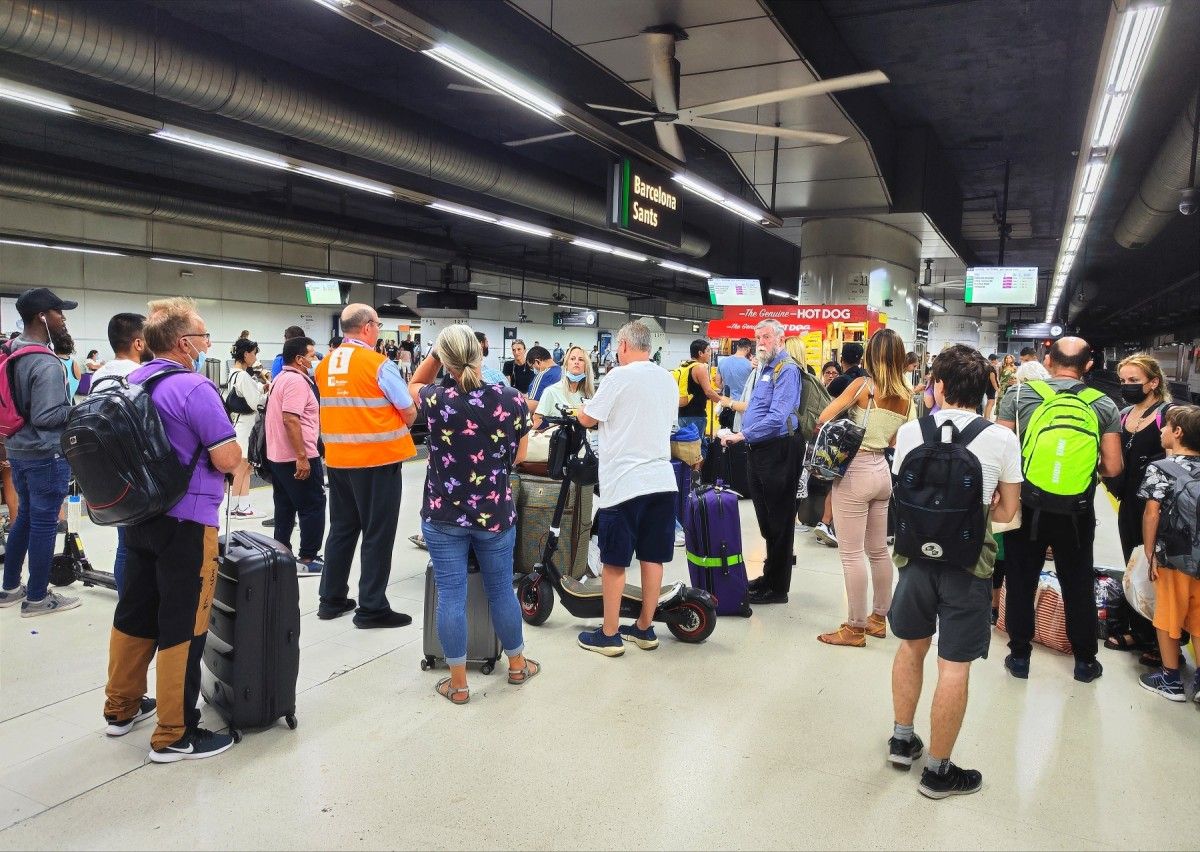 Passatgers a una andana de l'Estació de Sants esperant trens sense horari