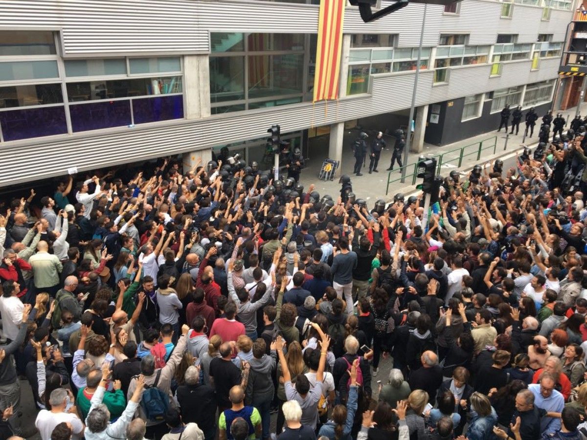 La policia espanyola encerclant la gent per treure les urnes de l'Escola Nostra Llar