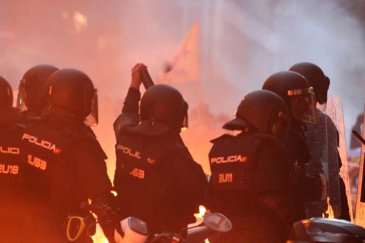 Policia espanyola enmig de flames en els aldarulls al centre de Barcelona del 18 d'octubre