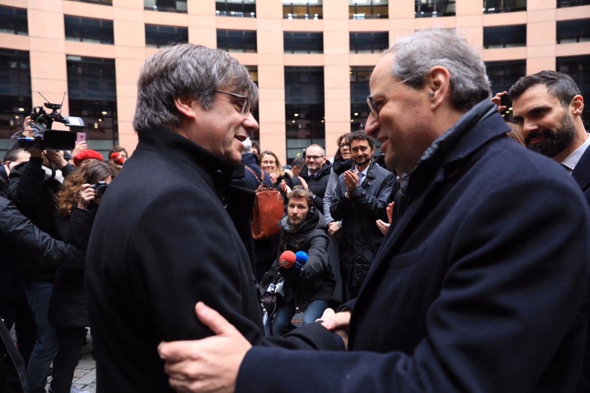 Quim Torra i Carles Puigdemont se saluden a Estrasburg sota la mirada de Roger Torrent