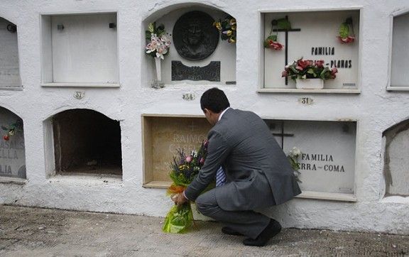 L'alcalde Ramon Roqué posa un ram de flors a la tomba de Raimon Casellas.