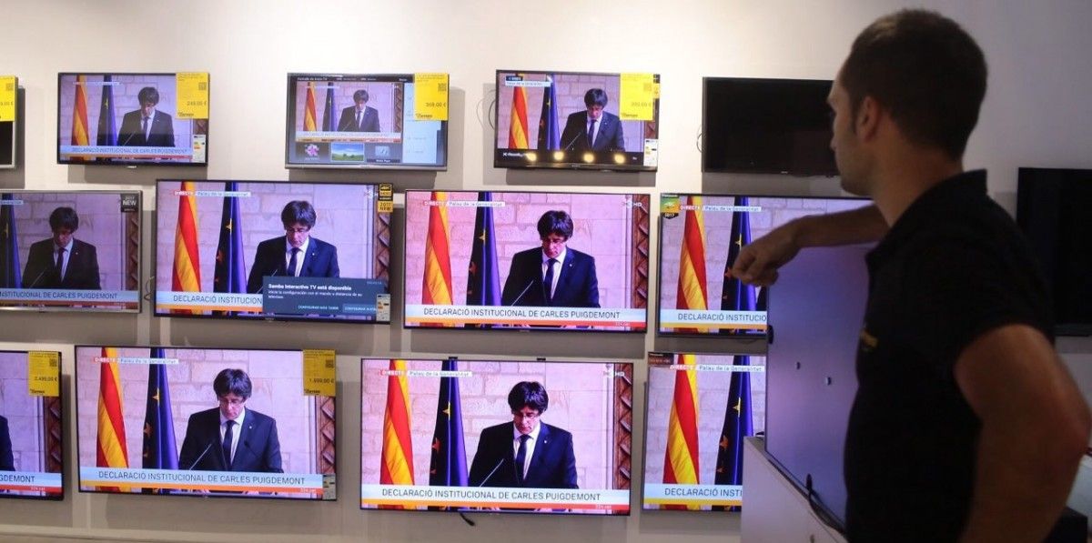 Un ciutadà segueix la compareixença de Carles Puigdemont aquest dijous a Palau