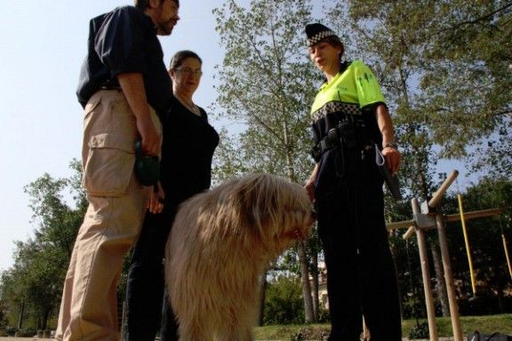 Un agent de la Policia Municipal, informant els propietaris d'un gos, en una foto d'arxiu