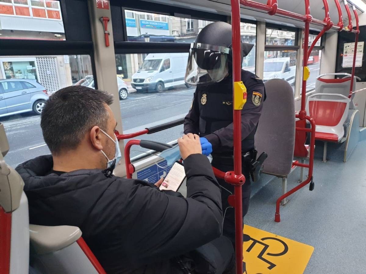 Guàrdia Civil repartint una mascareta en un bus.