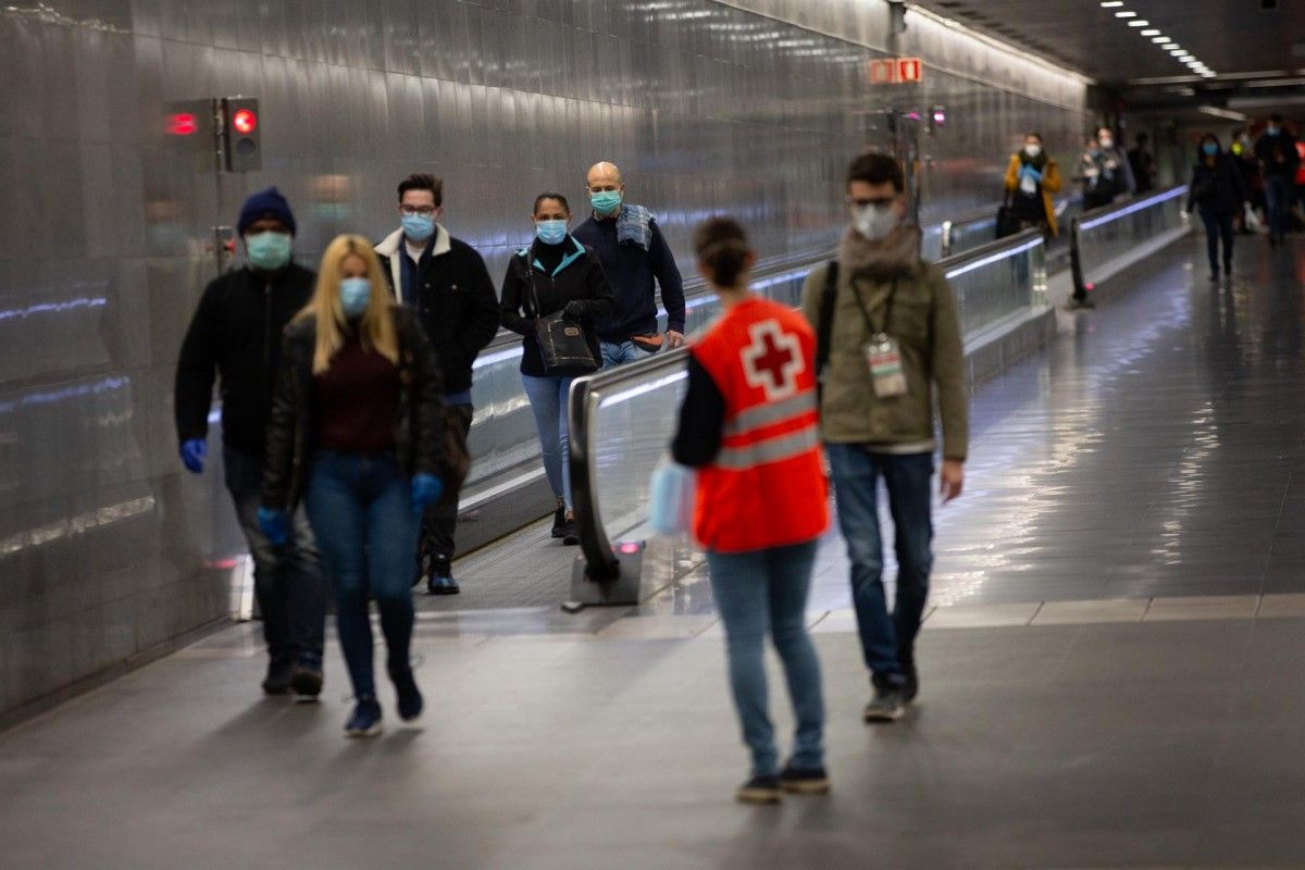 Voluntaris de Creu Roja repartint mascaretes als passatgers del metro.