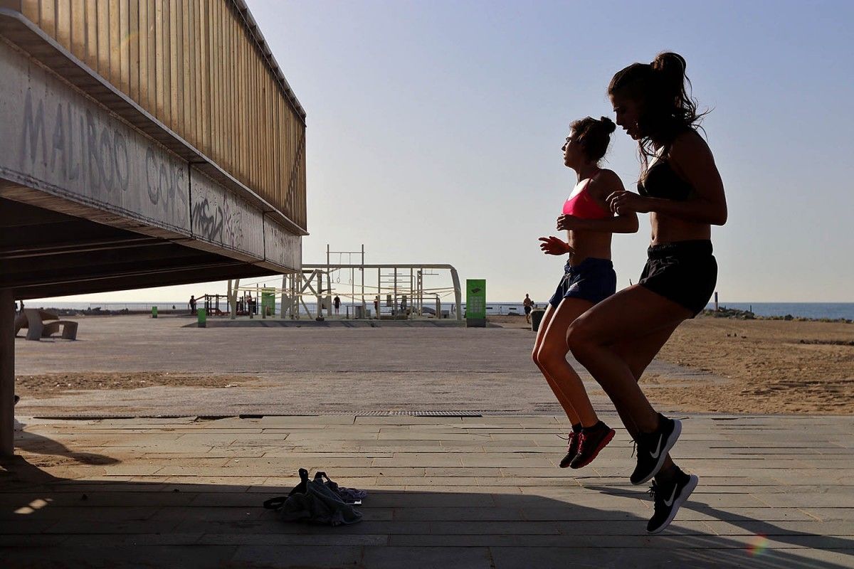 Dues noies fan exercici en una platja a Barcelona
