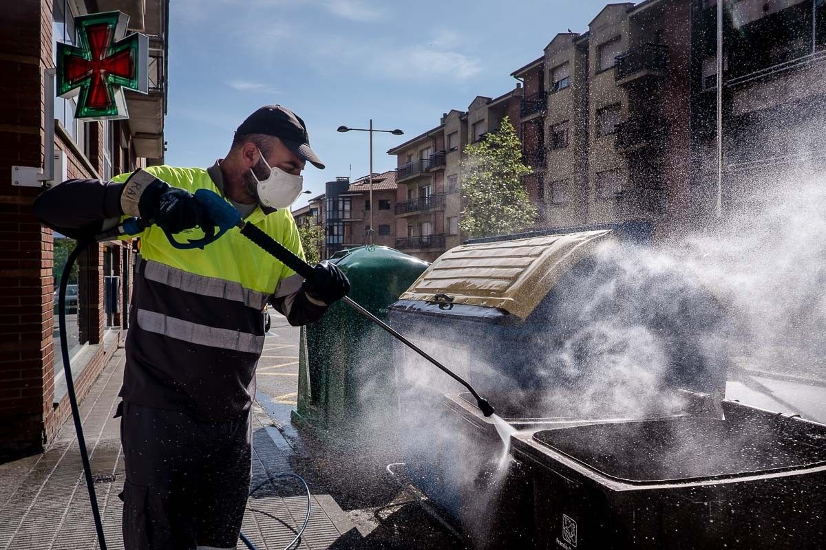 Un operari desinfectant els contenidors en plena pandèmia