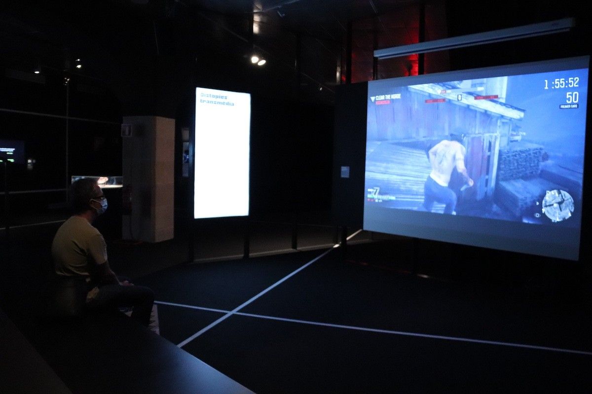 Una persona observant un dels continguts audiovisuals de l'exposició 'Gameplay' el dia de la reobertura