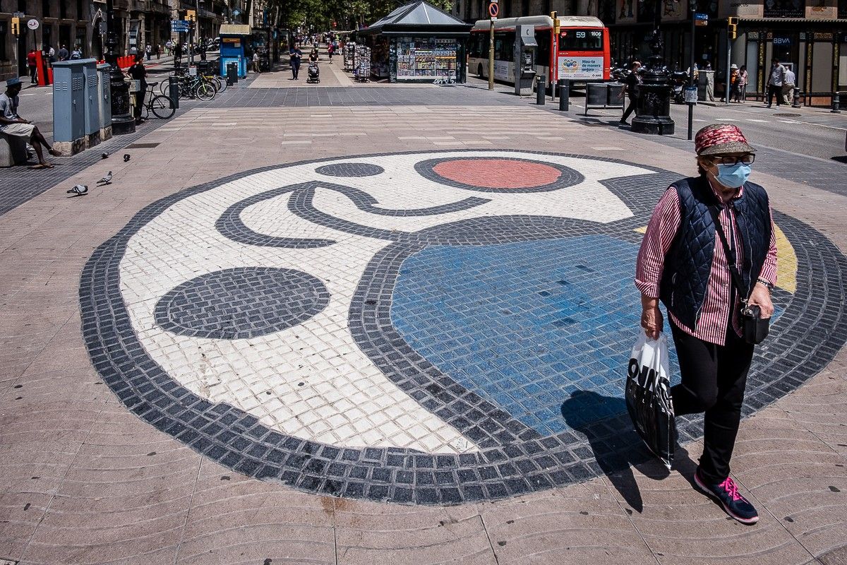 Un ciutadà de Barcelona passeja amb mascareta per la Rambla, buida de turistes.