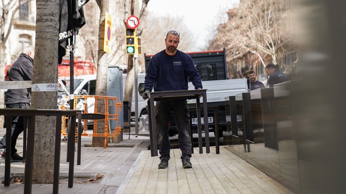 Un operari muntant una terrassa amb plataforma definitiva, a Barcelona