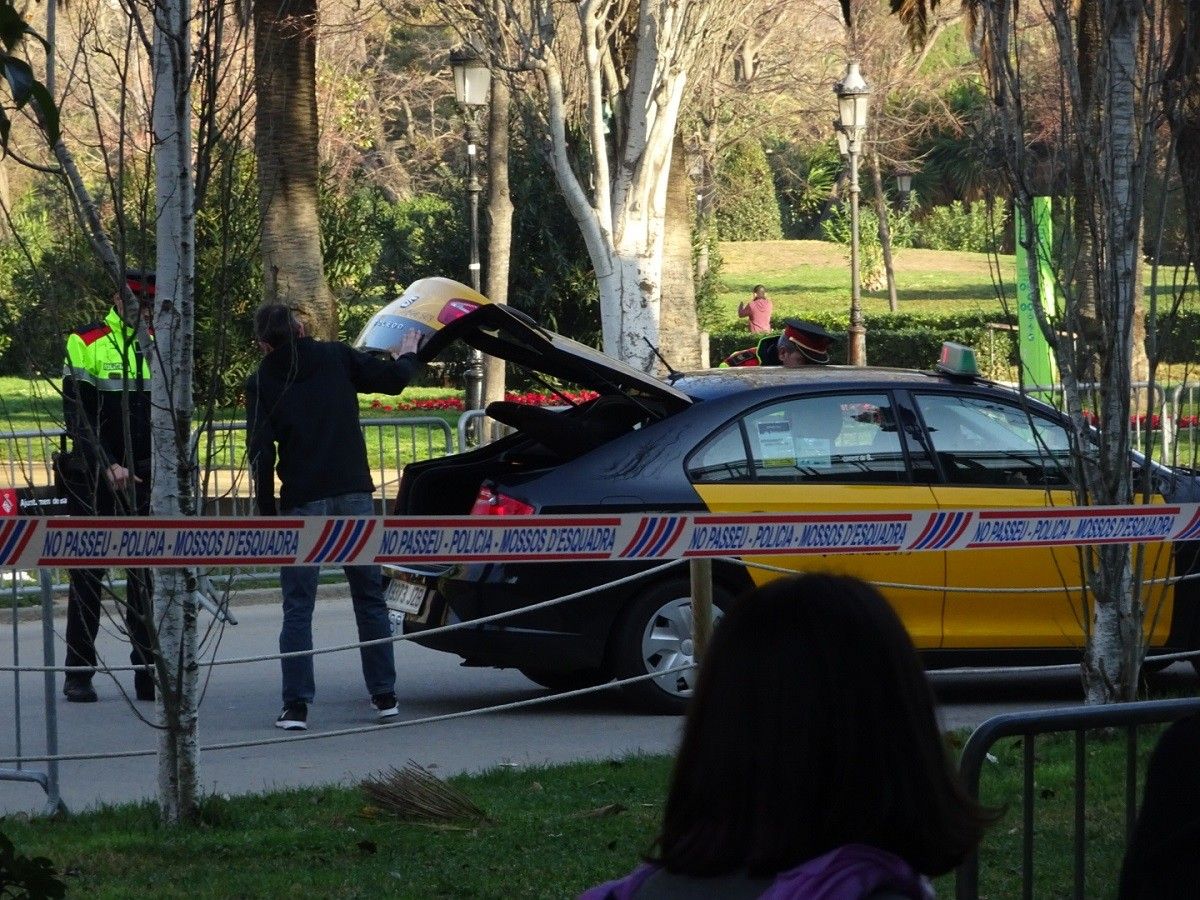 Un agent dels Mossos registra el maleter d'un taxi a les portes del Parc de la Ciutadella.