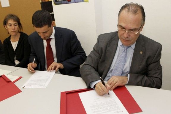 El secretari general de Càritas Girona, Miquel Batllori, i el president de la Diputació, Jaume Torremadé, durant la signatura del conveni