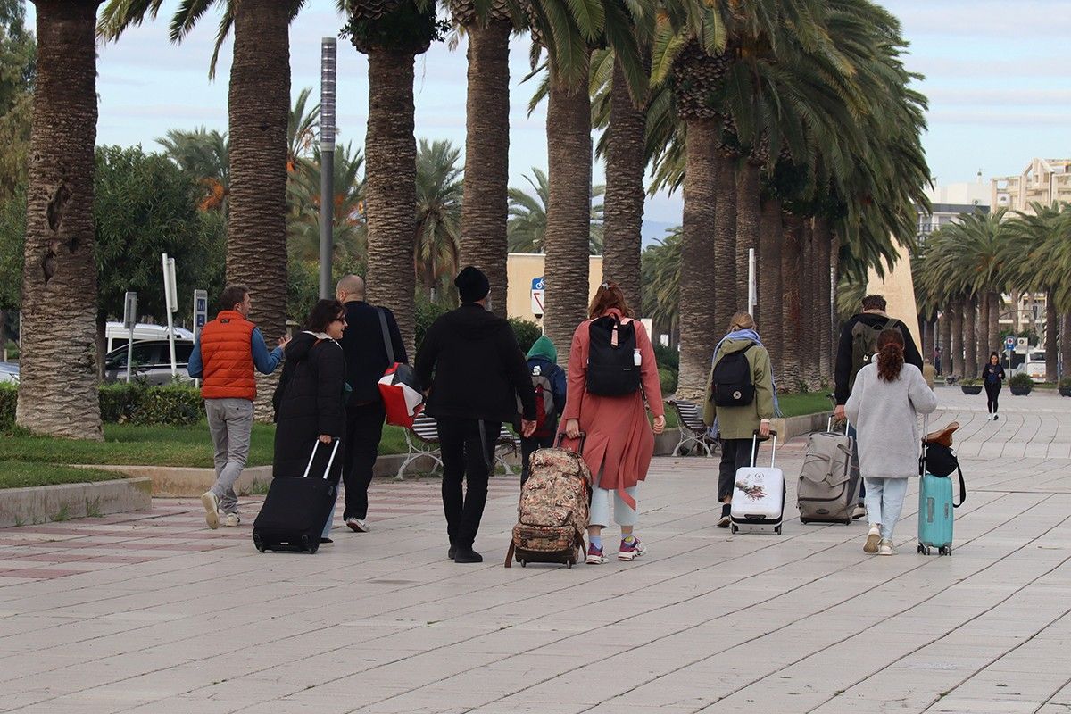 Un grup de persones amb maletes caminant per Salou