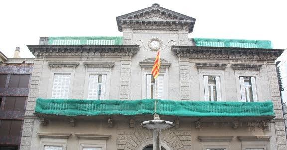 La façana de l'Ajuntament de Banyoles sense banderes per les obres al balcó i davant una senyera penjada pels concentrats que ahir al vespre van protestar davant de l'edifici.