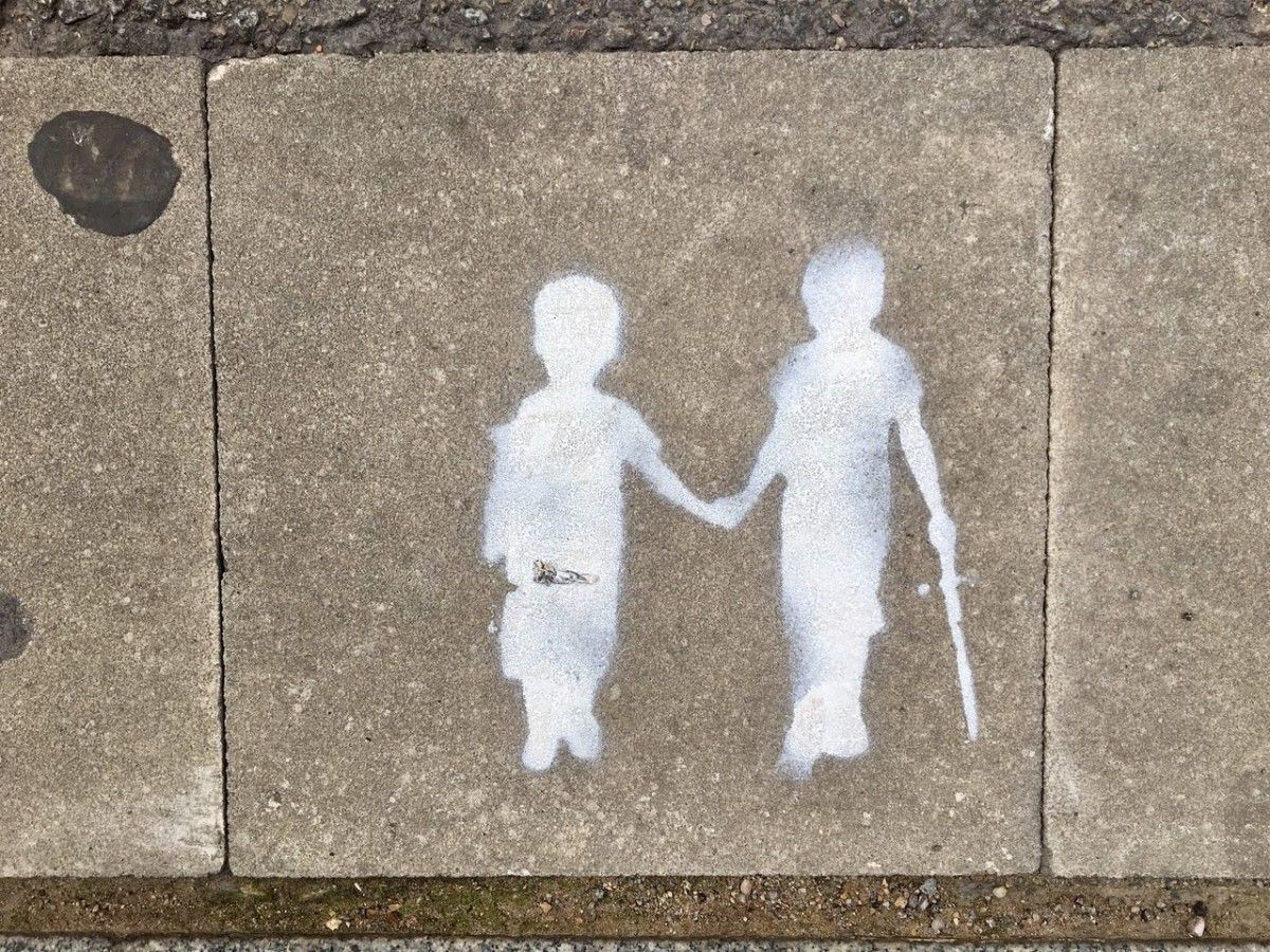 La pintada a terra dels dos nens agafant-se de la mà