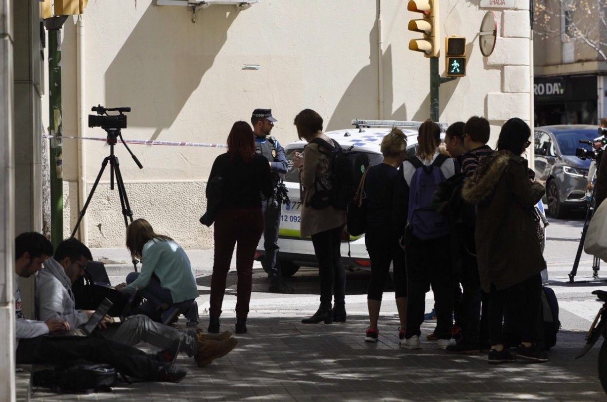 Curiosos i periodistes treballant al carrer on hi ha hagut el presumpte assassinat