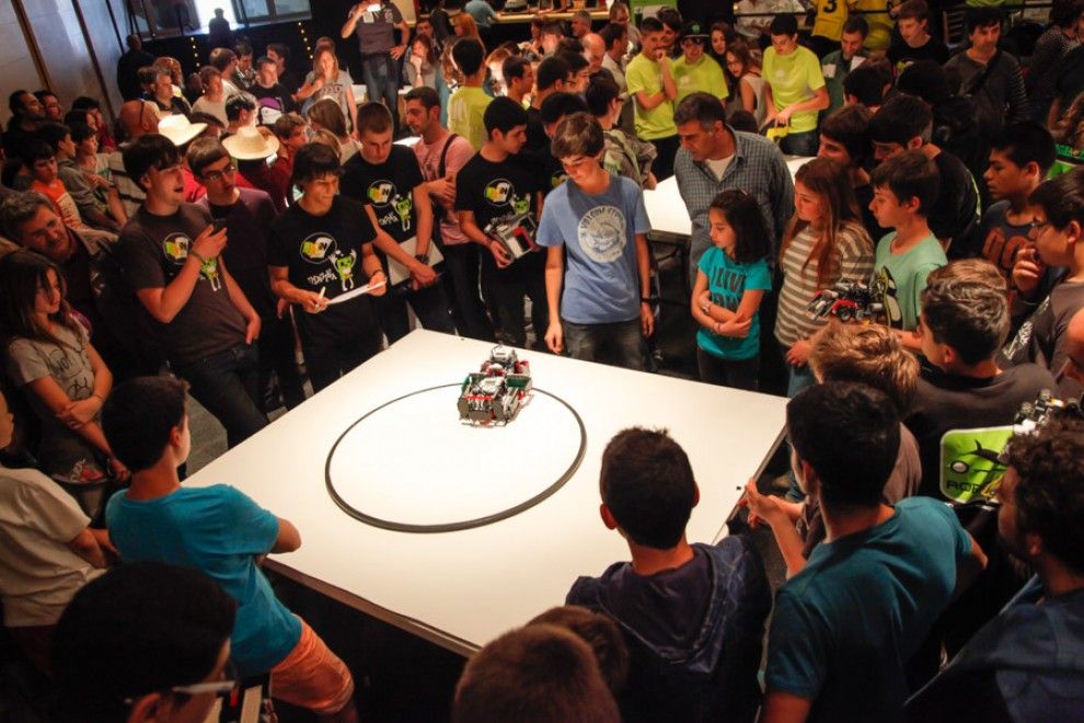 Joves observant el funcionament d'un robot