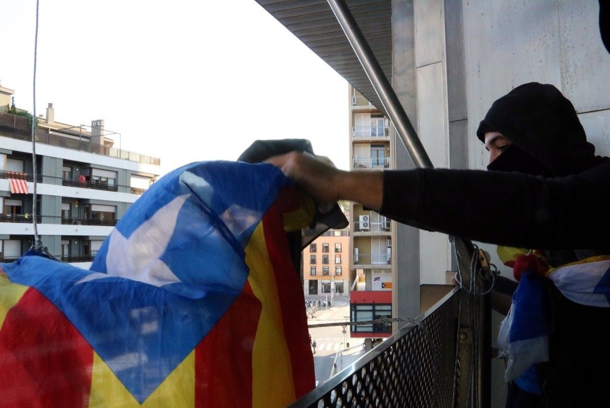 El moment en què un dels manifestants va penjar una estelada al balcó de la delegació del Govern a Girona l'1 d'octubre de 2018