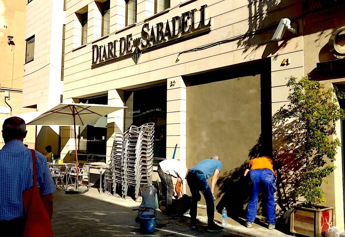 Operaris aixecant un mur a l'antic 'Diari de Sabadell'