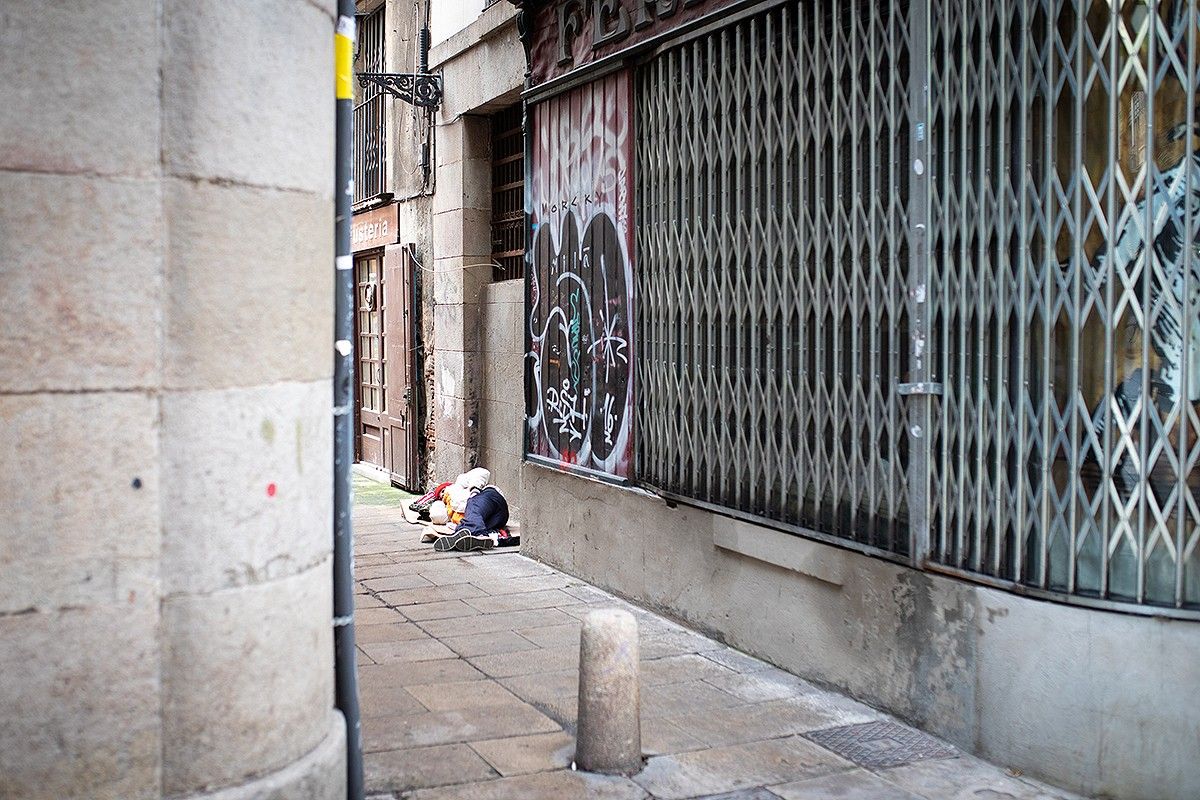 Una persona sense llar dormint al carrer, en imatge d'arxiu