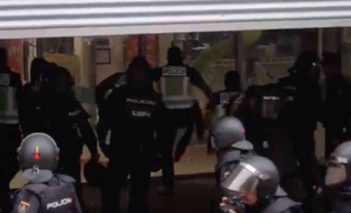 Un agent de la policia espanyola trenca el vidre de l'escola Nostra Llar de Sabadell