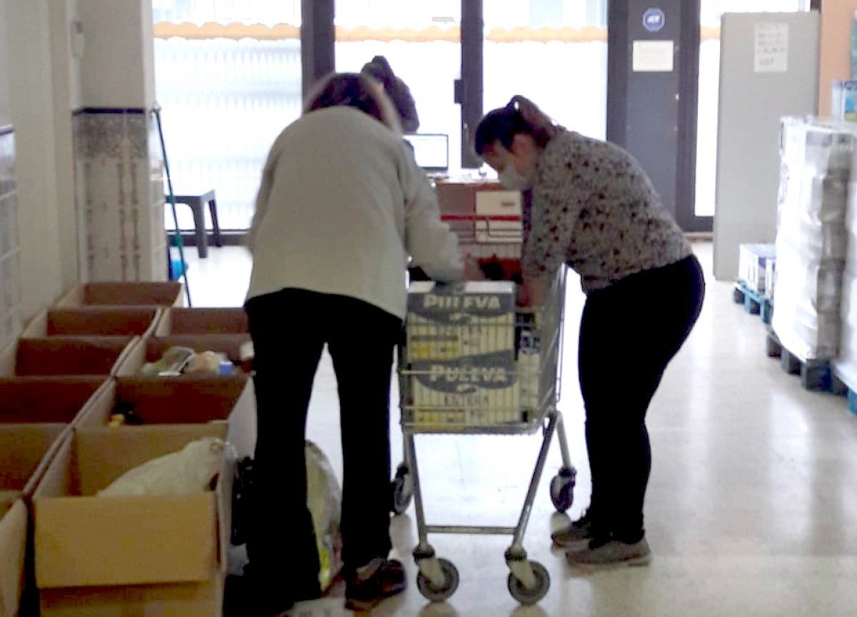 Uns voluntaris organitzen borses d'aliments a Olot.