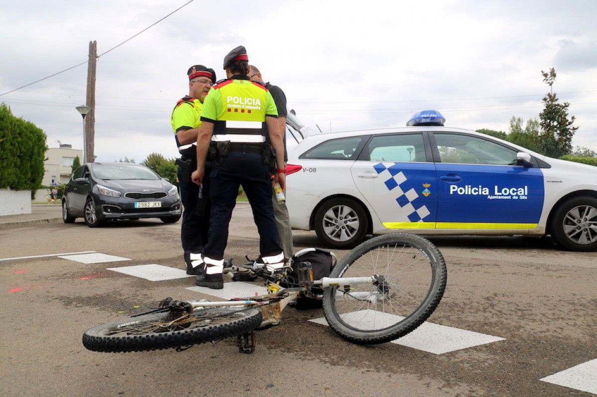 En primer terme, la bicicleta implicada en l'accident i al fons agents dels Mossos i de la Policia Local de Sils.