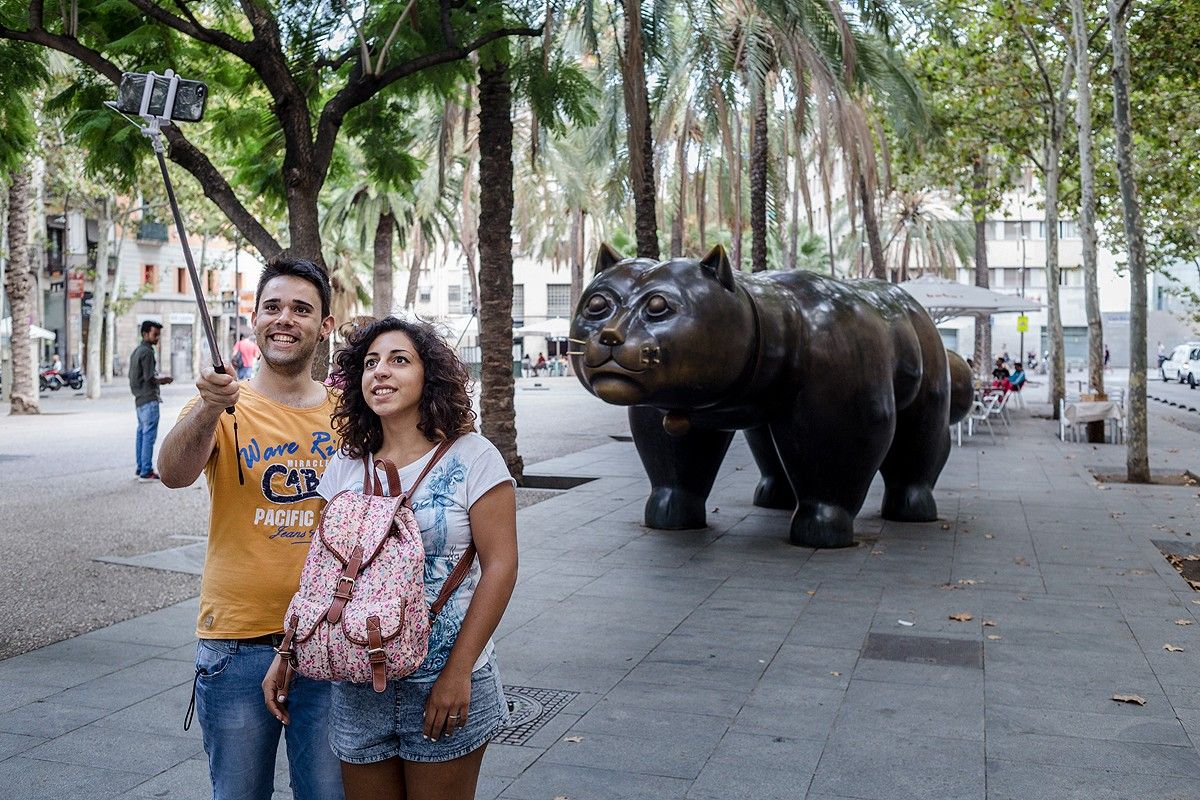 Una parella de turistes fent-se un «selfie» amb el gat del Raval de Fernando Botero