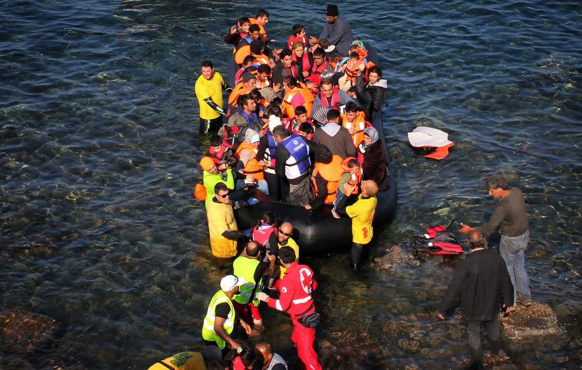 Ajudant a sortir gent d'una barca que ha arribat a una zona rocosa