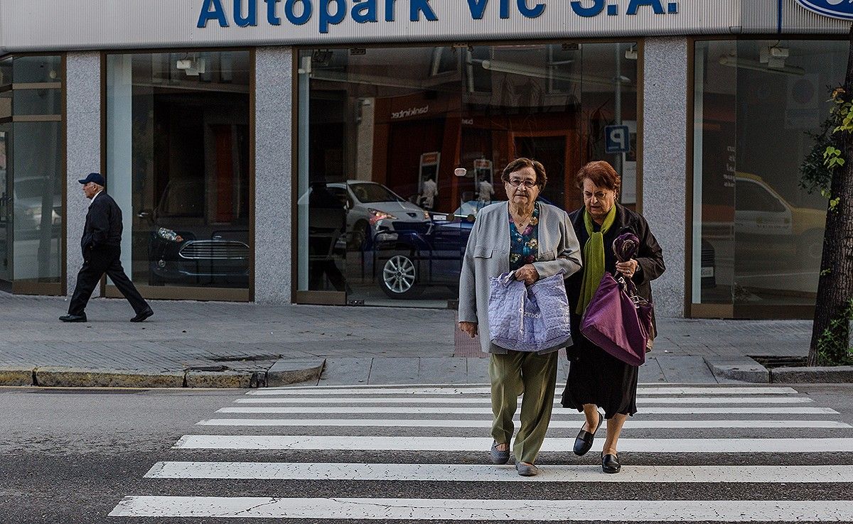 Dues dones creuant un pas de vianants del carrer Verdaguer de Vic