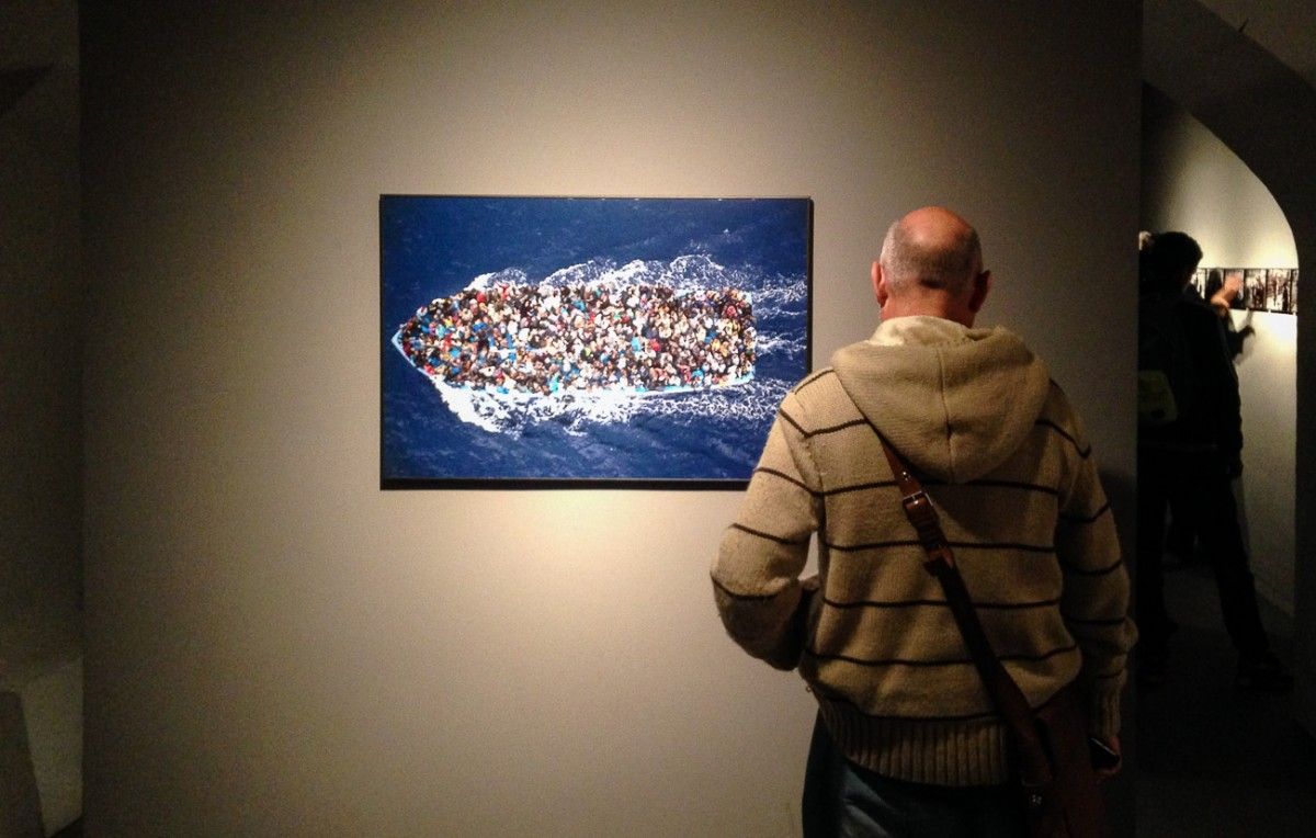 Un home mira una de les fotos del World Press Photo 2015 exposades al CCCB