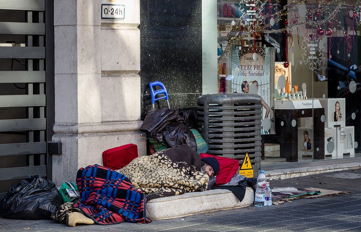 Un home dormint al carrer, al centre de Barcelona