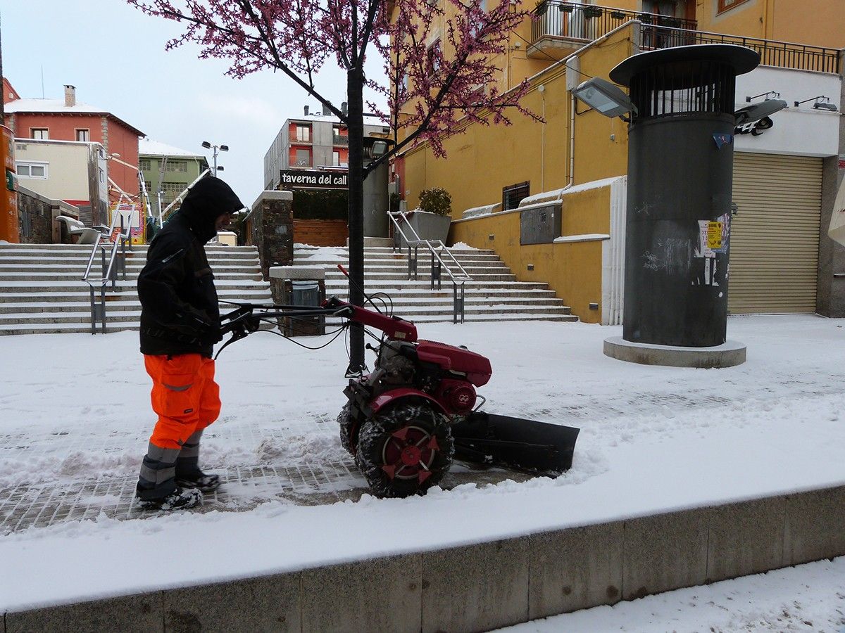 Uns operaris netejant neu en un carrer.