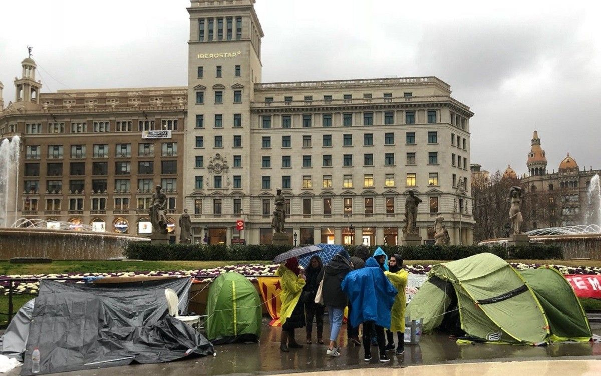 Una desena de persones, acampades a Plaça Catalunya, malgrat la pluja, per exigir que es desencalli la investidura.