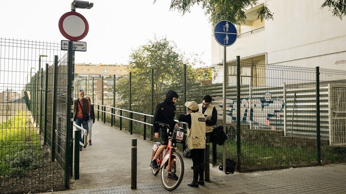 Dos informadors expliquen a un usuari de bicicleta la nova senyalització