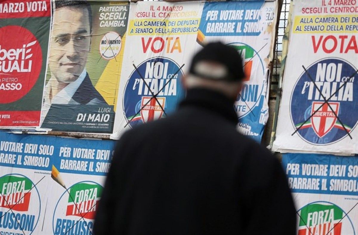 Un ciutadà italià observa els cartells electorals per a les eleccions d'aquest diumenge.