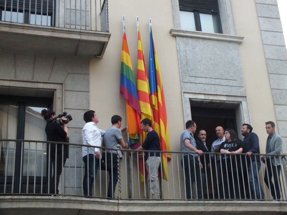 La majoria de consellers i els representants de TALCOMSOM al balcó del Consell Comarcal del Ripollès amb la bandera de l'arc de sant Martí hissada de fons