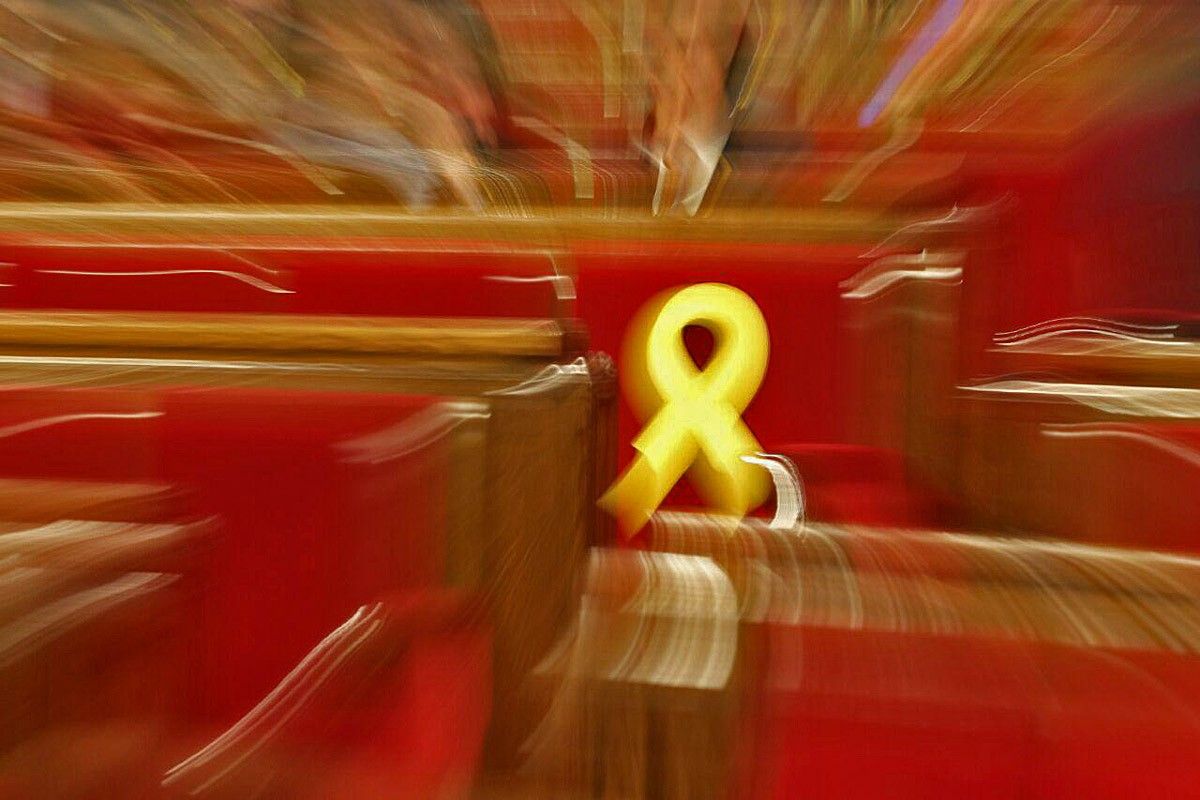 Un llaç groc en un escó durant el ple del Parlament de l'1 de març
