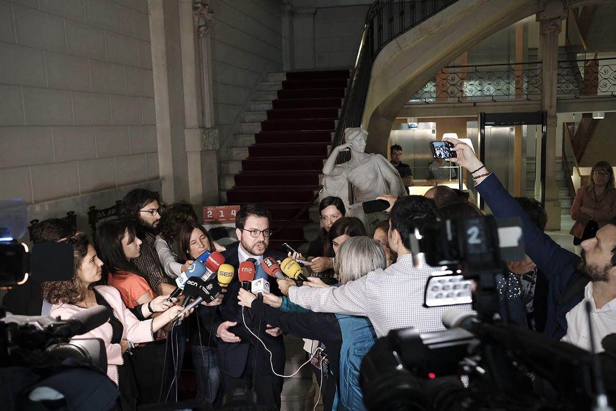 Pere Aragonès, acompanyat d'una imatge d'Oriol Junqueras, a la seva arribada a Economia