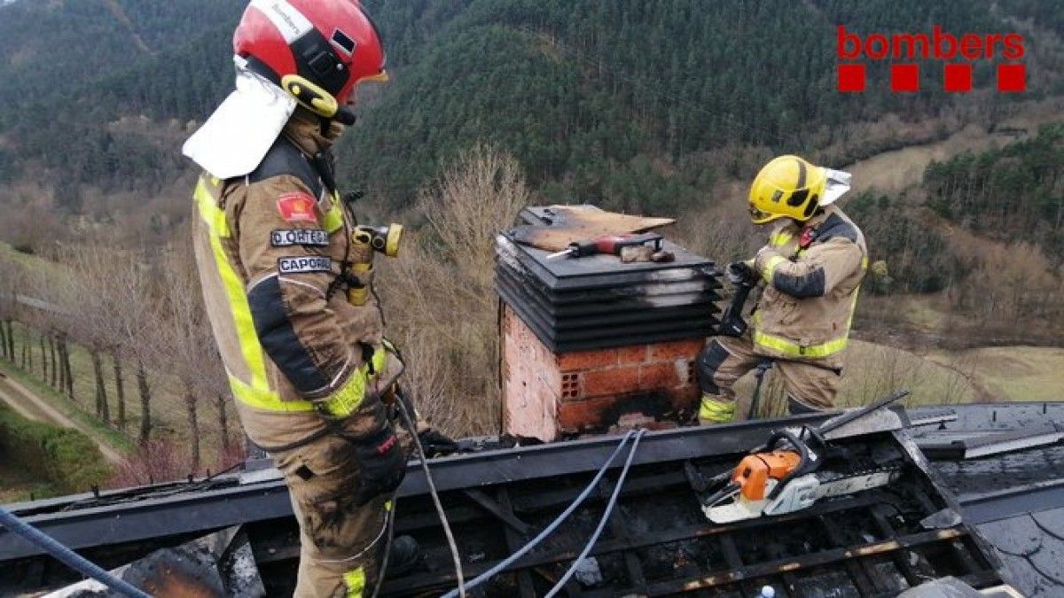 Dos bombers treballant a la teulada