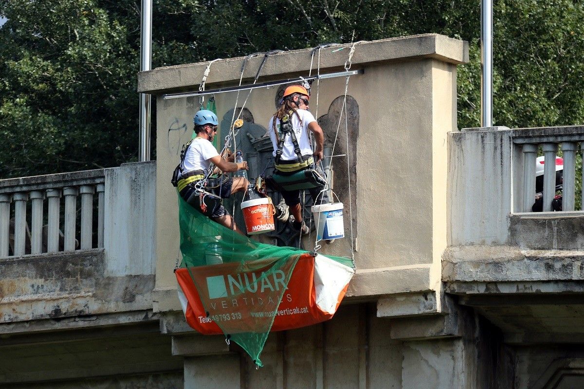 Els operaris retirant les àligues del pont que uneix Girona i Sarrià de Ter