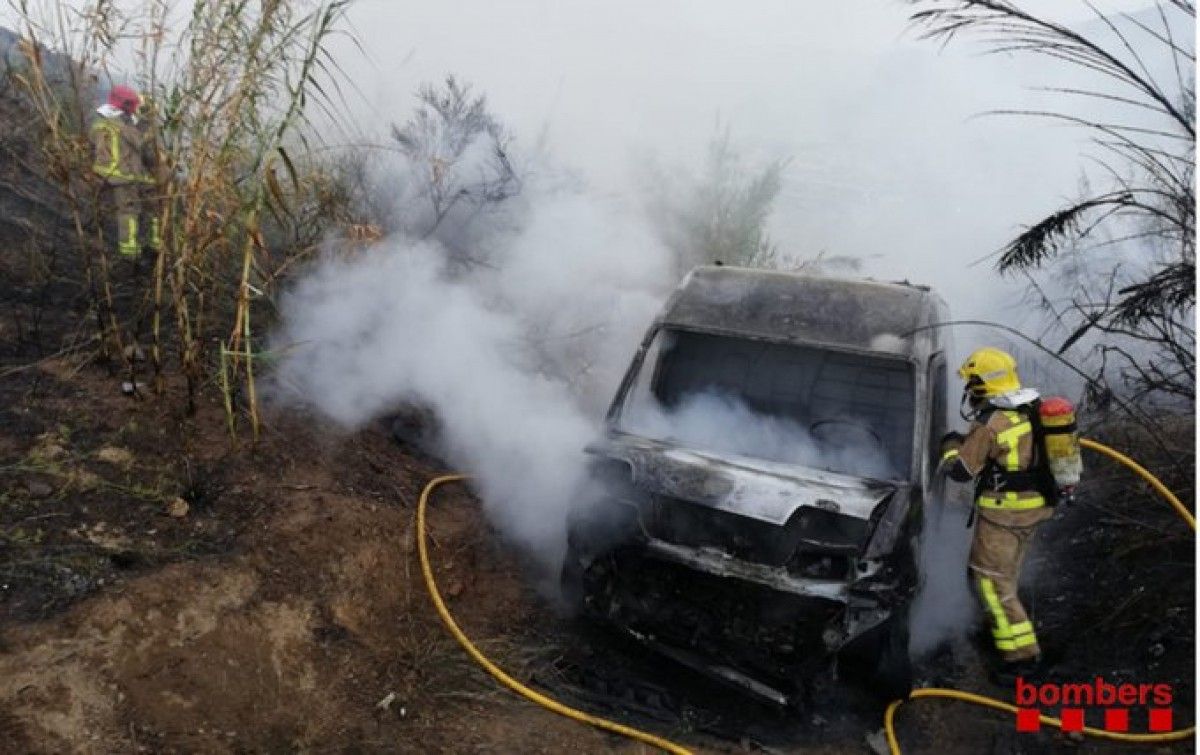 Un bomber apagant el foc del vehicle incendiat 