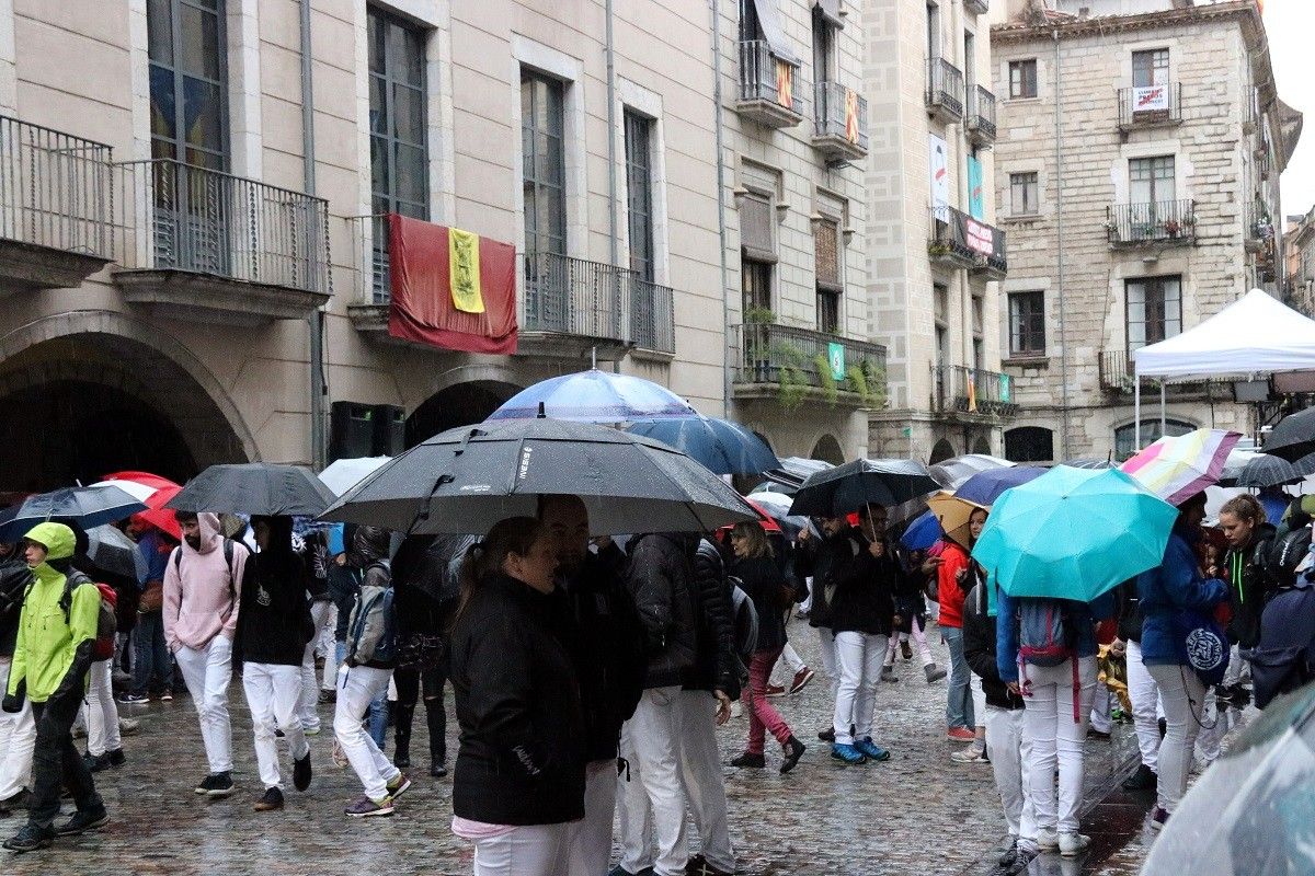 Pla general de la Plaça del Vi i els castellers amb paraigua aquest diumenge a Girona