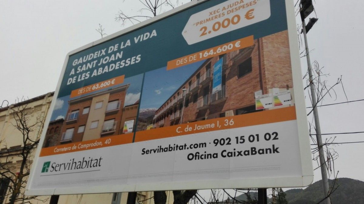 L'anunci de pisos de Sant Joan de CaixaBank col·locat en un cartell  publicitari de Ripoll al carrer del Ter